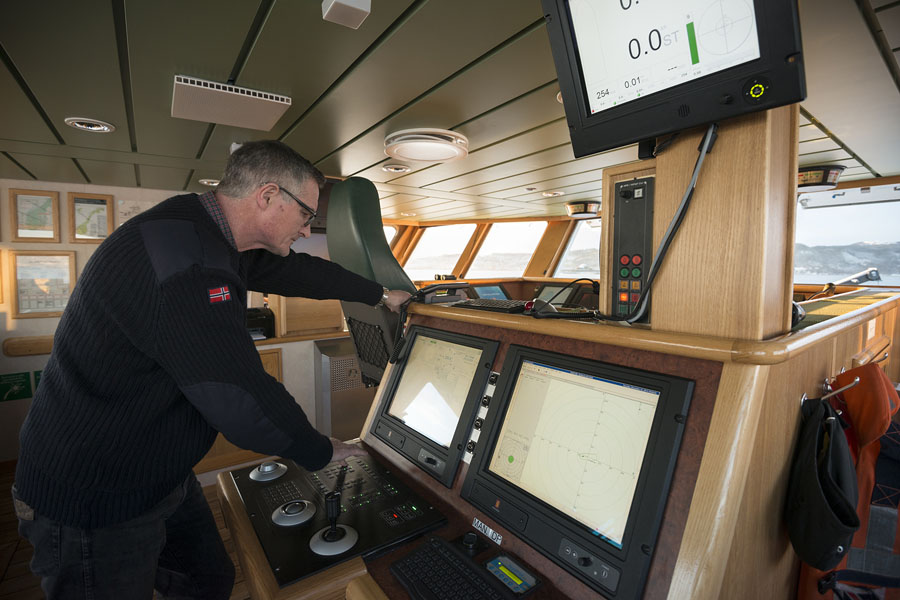 Kaptein Arve Knudsen foran styringspanelet på F/F Gunnerus. Foto: Henning Langlete / Kongsberg Seatex